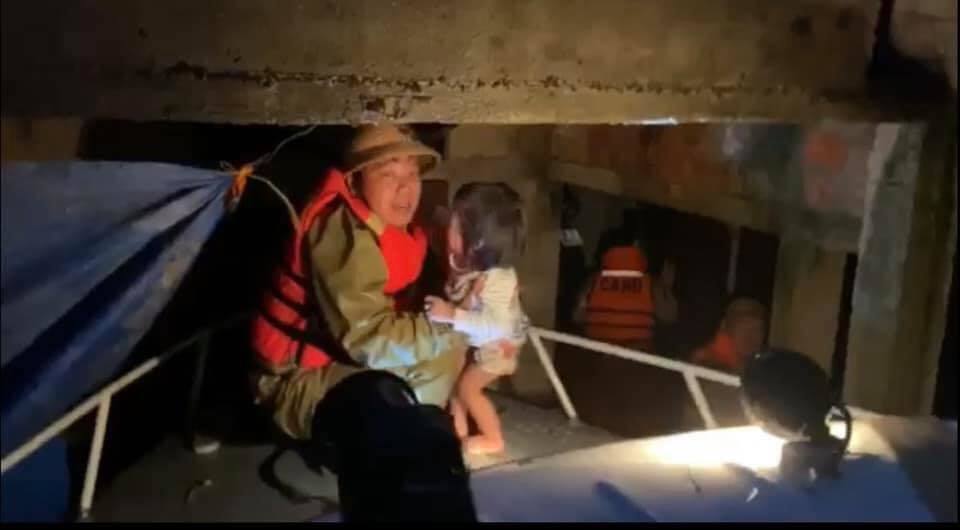  
Một em bé được đưa ra khỏi căn nhà bị ngập gần hết trong nước lũ. (Ảnh: Quảng Trị 24h)