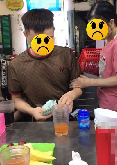  
Thanh niên trả tiền hộp kẹo cao su cho người bán hàng rong. (Ảnh: Cắt từ clip)