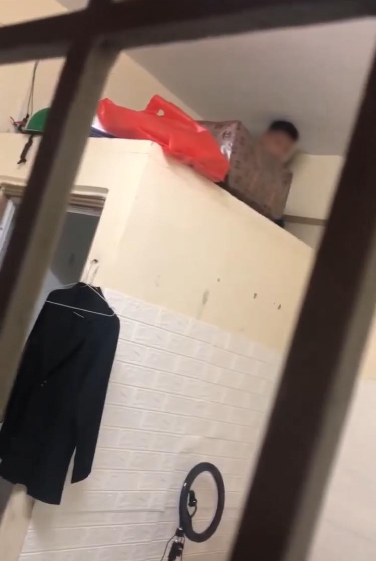  
Thanh niên bị phát hiện trên nóc nhà vệ sinh. (Ảnh cắt từ clip)