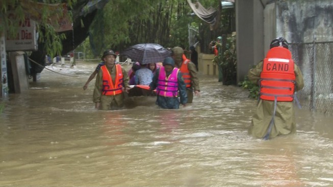
Lực lượng chức năng giúp người dân di chuyển trong mưa lũ. (Ảnh: Pháp Luật Online).