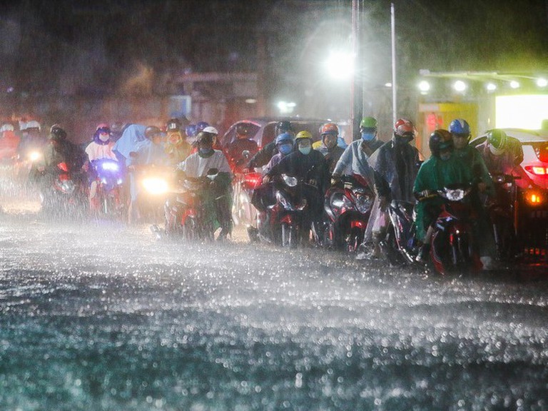  
Đường ngập nặng do mưa và triều cường dâng, người dân phải dắt xe máy lưu thông trên đường. (Ảnh: Thanh Niên)