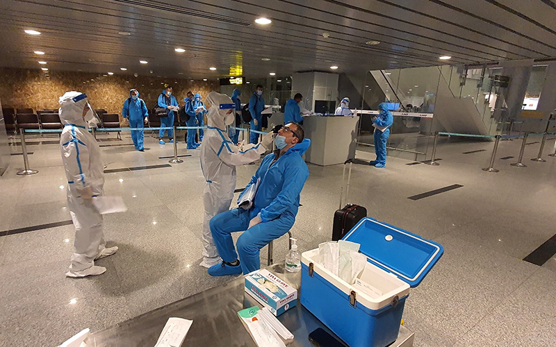 
Nhân viên y tế thực hiện xét nghiệm tại sân bay. (Ảnh: Nhân Dân).