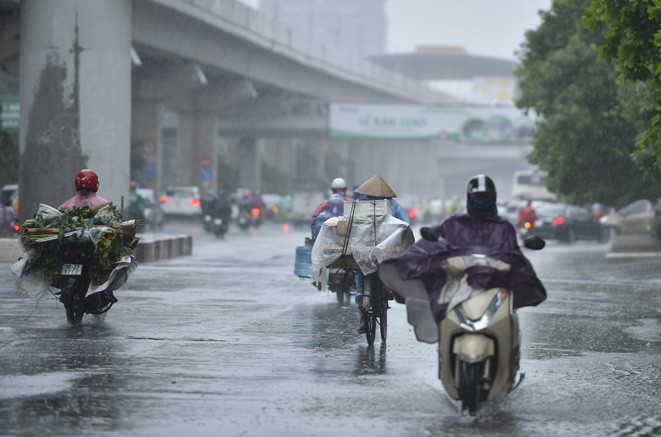 
Hình ảnh người dân di chuyển trong cơn mưa lớn. (Ảnh: Tiền Phong)