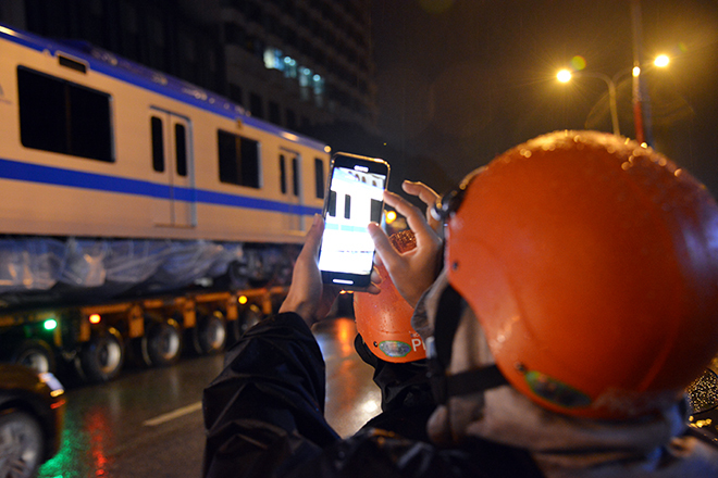  
Người dân phấn khích ghi lại hình ảnh khi toa tàu được vận chuyển. (Ảnh: VTC).
