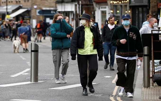  
Người dân tại Anh đeo khẩu trang khi đến nơi công cộng. (Ảnh: Reuters)