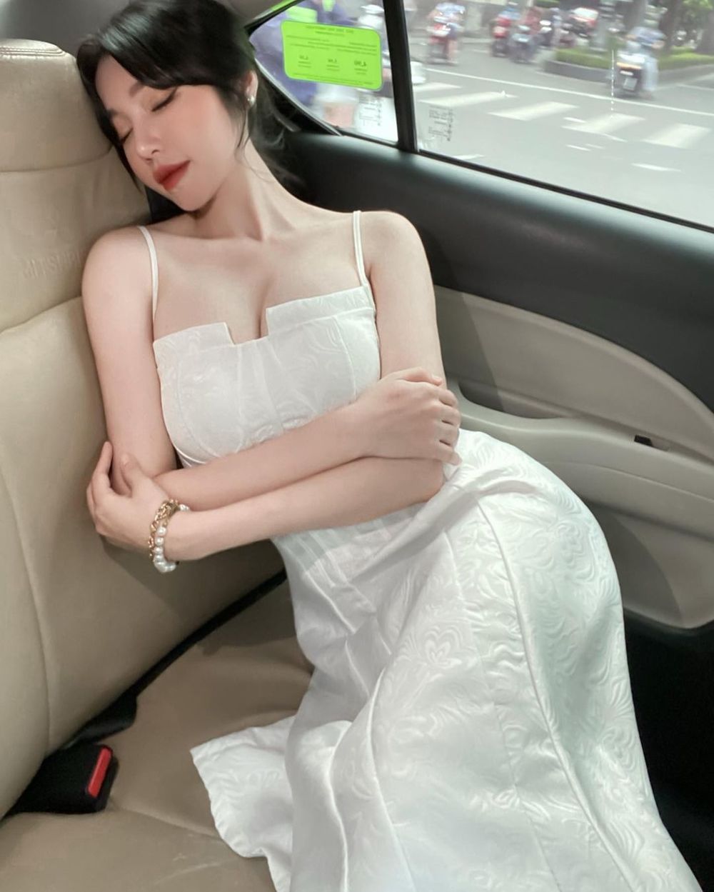  
Elly Trần chia sẻ hình ảnh ngủ gục trên xe cũng khiến người xem phải trầm trồ, cô diện chiếc đầm hai dây màu trắng trẻ trung. (Ảnh: FBNV)