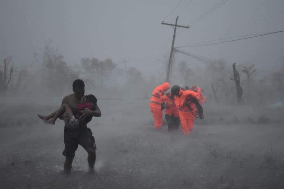  
Người dân và lực lượng cứu hộ vật lộn khi bão Vamco đổ bộ Philippines. (Ảnh: Marco Chavez).