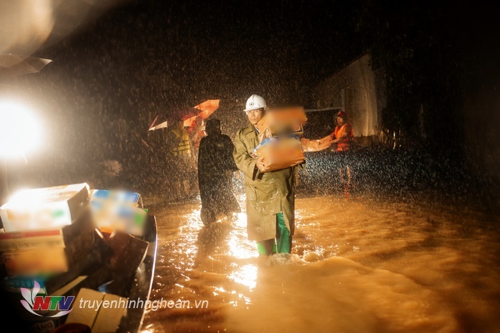  
Từng kiện hàng được đem phân phát gấp trong đêm mưa lớn cho người dân Nghệ An. (Ảnh: Truyền Hình Nghệ An)