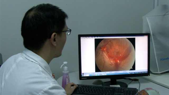  
Bác sĩ đang xem kết quả kiểm tra của Xiao Chen. (Ảnh: Pear Video)