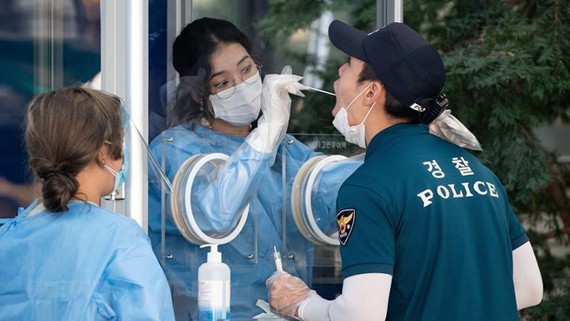 
Nhân viên y tế tiến hành lấy mẫu bệnh phẩm ở Hàn Quốc. (Ảnh: Yonhap).