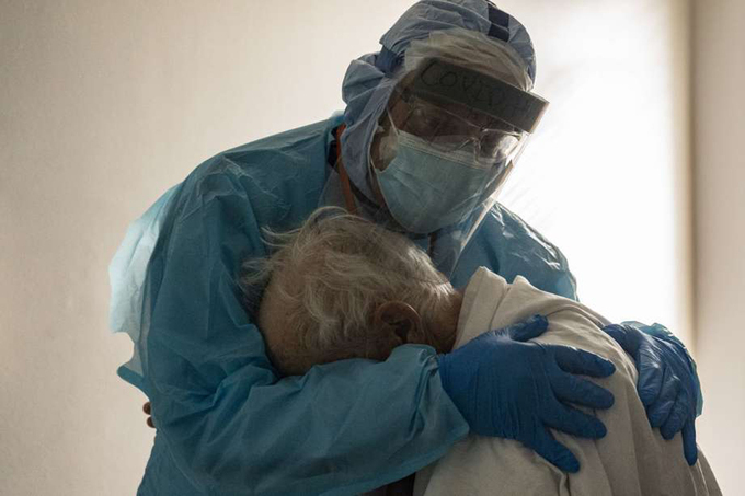  
Bác sĩ Joseph Varon an ủi cụ ông mắc Covid-19 tại Trung tâm Y tế United Memorial. (Ảnh: Nakamura)