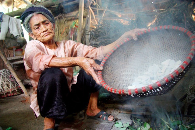  
Cụ Biện đang ngồi hun khói đất ngói với lá sim.