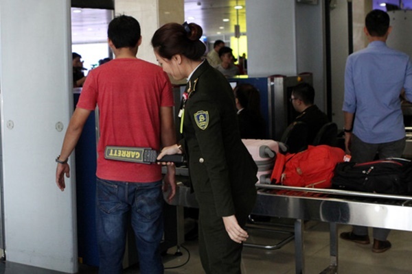 
Nhân viên an ninh kiểm tra hành khách tại ga đi trong nước, sân bay Tân Sơn Nhất (Ảnh: Tạp chí Hàng Không)
