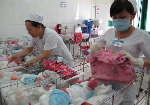  
Nhân viên y tế chăm sóc cho các trẻ mới sinh. (Ảnh: Người Lao Động)