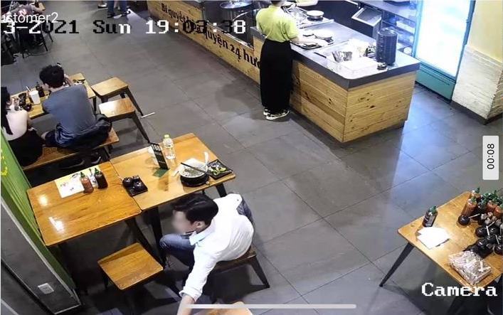  
Hình ảnh cắt từ camera ghi lại khoảnh khắc nam thanh niên đang với tay lấy điện thoại của nhân viên. (Ảnh: FB H.D)