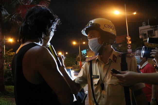  
Cảnh sát giao thông thực hiện việc đo nồng độ cồn cho nam thanh niên. (Ảnh: Dân Việt).