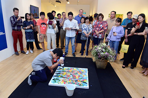  
Xèo Chu thể hiện khả năng của mình trong buổi triển lãm tranh. (Ảnh: VnExpress)