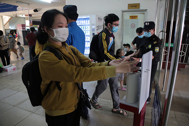  Người dân được kiểm tra thân nhiệt, rửa tay sát khuẩn trước khi lên xe (Ảnh: Dân Việt)