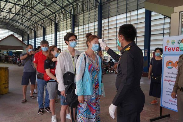  
Hành khách được đo thân nhiệt tại sân bay để phòng dịch Covid-19. (Ảnh: Bangkok Post)