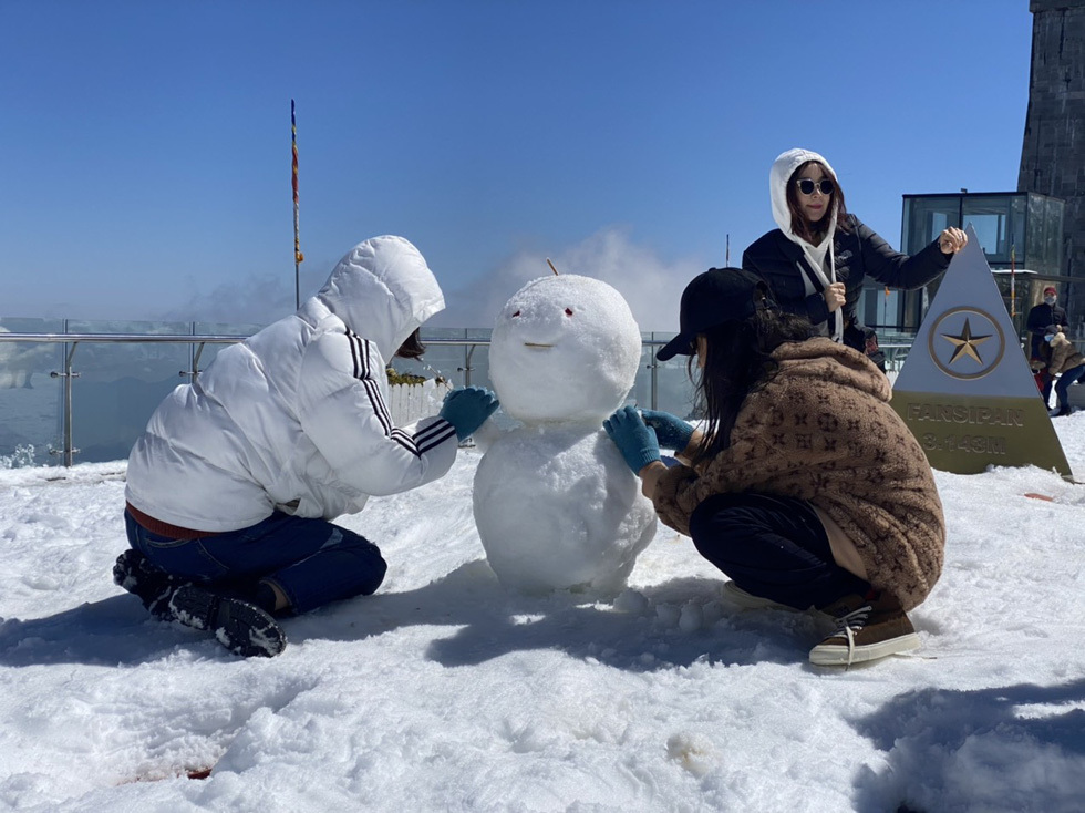  
Các bạn trẻ đang tạo người tuyết trên đỉnh Fansipan. (Ảnh: Tuổi trẻ)