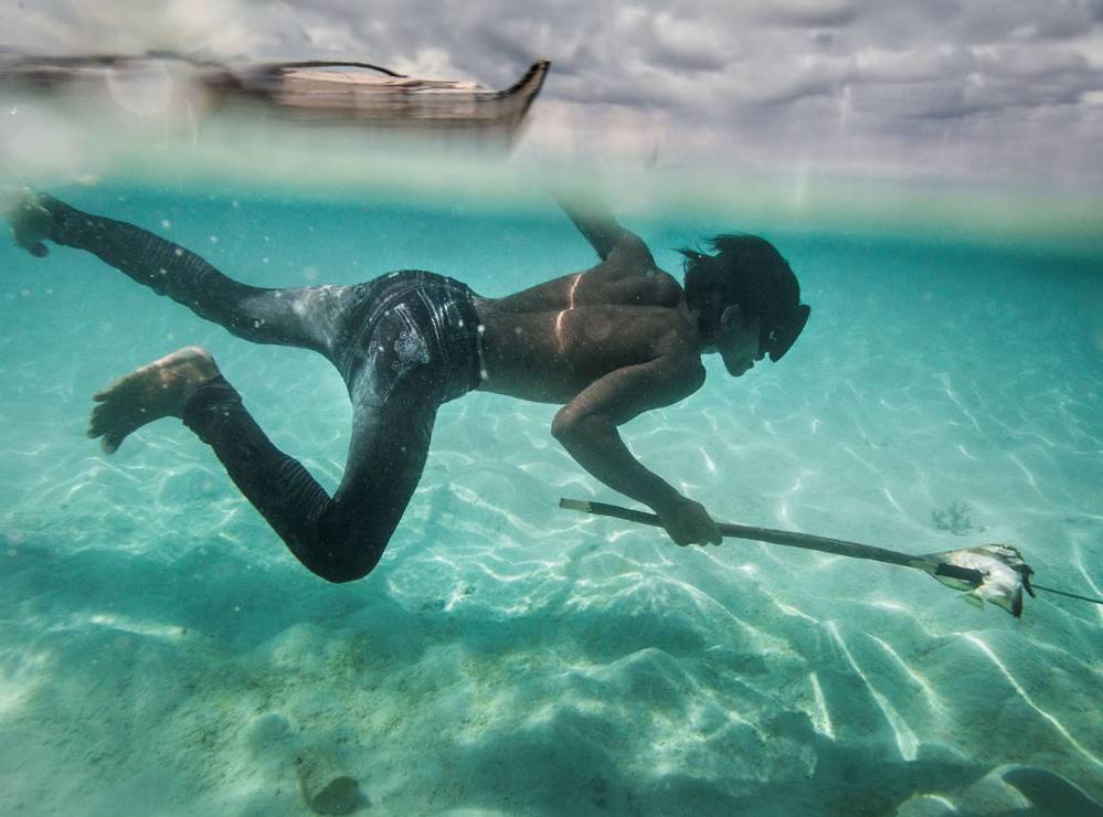  
Cận cảnh một thanh niên đang "săn mồi" dưới biển. (Ảnh: Matthieu Paley/NatGeo)