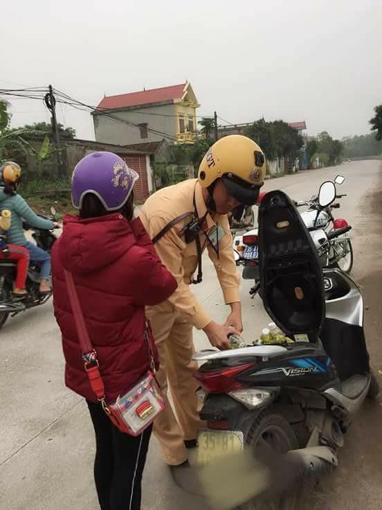  
Chiến sĩ áo vàng giúp đỡ cô gái đổ xăng vì xe hết xăng giữa đường. (Ảnh: FB H.E)