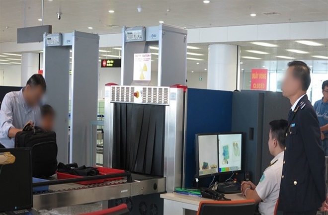  
Nhân viên sân bay kiểm tra, soi chiếu hành lý xách tay của hành khách. (Ảnh: VnExpress)