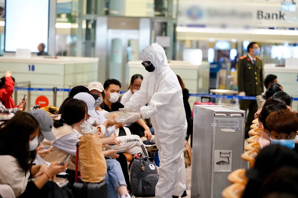  
Nhân viên y tế hỗ trợ người nhập cảnh tại sân bay trước khi đưa đi cách ly. (Ảnh: Bộ Y Tế)