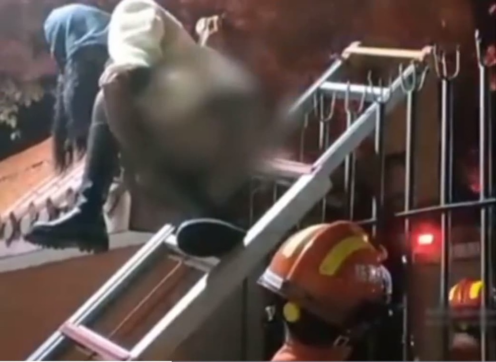  
Nhân viên cứu hỏa đã phải nhanh chóng đưa thang lên để nữ sinh bước xuống. (Ảnh: Chụp màn hình)
