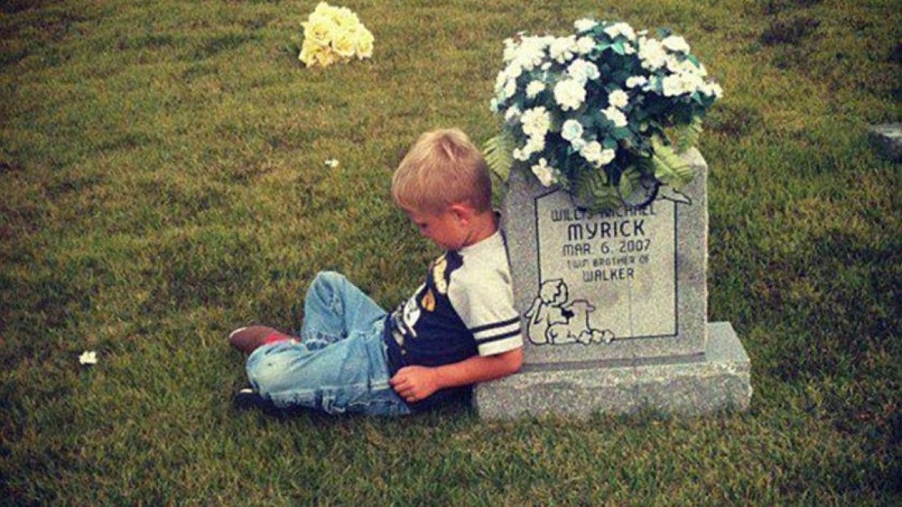  
Hình ảnh cậu bé Walker Myrick ngồi bên mộ em trai của mình. (Ảnh: Mirror)
