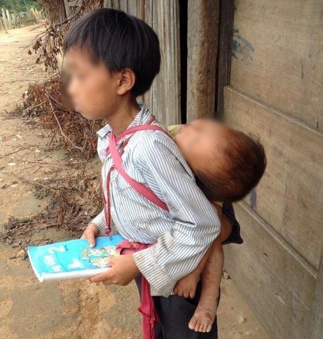  
Hay như hình ảnh cậu bé lớp 2 ở Nghệ An địu em đi học khiến nhiều người nghẹn lòng. (Ảnh: Thanh Niên)