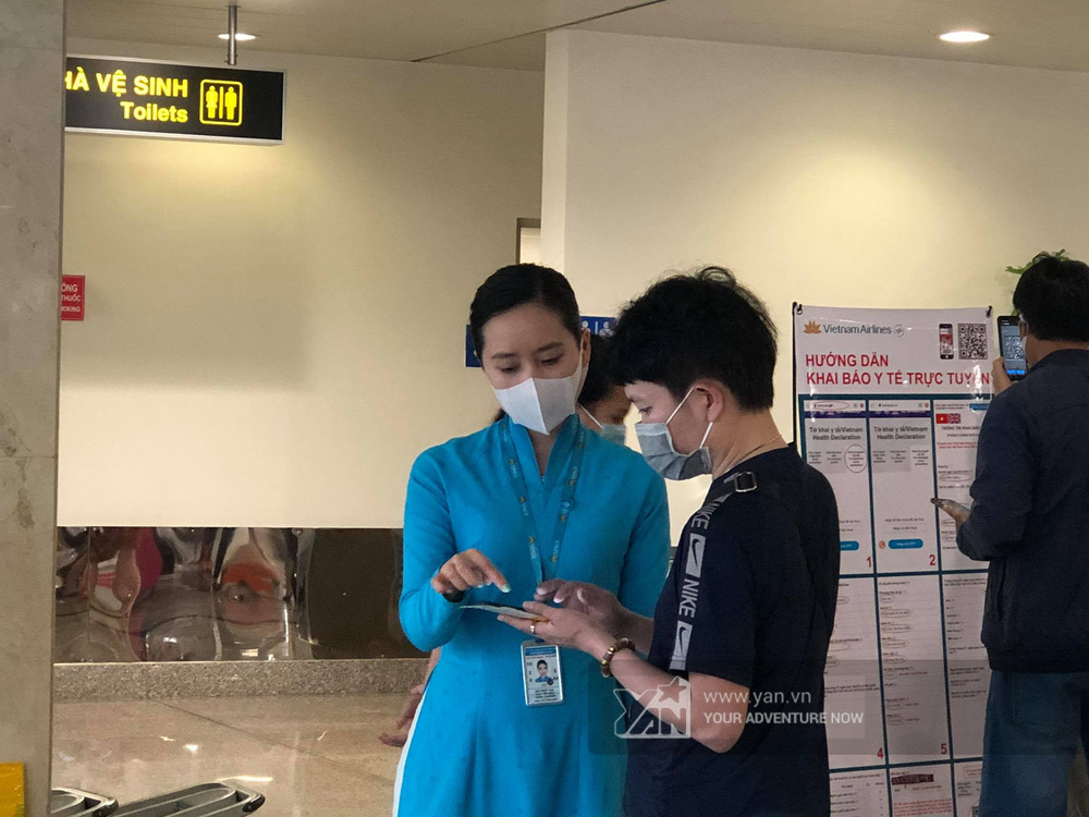  
Nhân viên hỗ trợ hành khách làm tờ khai y tế. 
