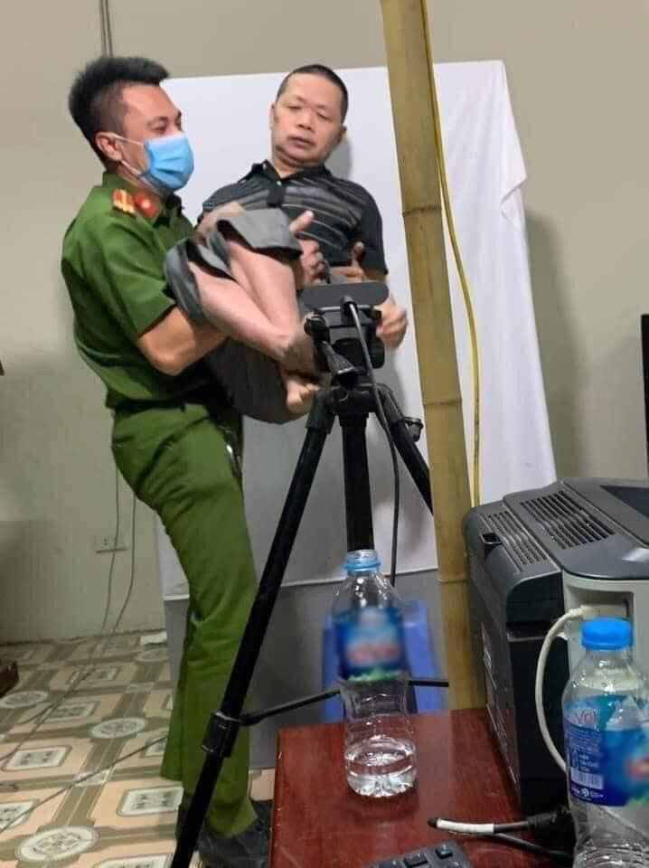  
Chiến sĩ công an bế hẳn người đàn ông lên để giúp họ chụp ảnh. (Ảnh: Công an thành phố Hà Nội, Công an tỉnh Thừa Thiên Huế)