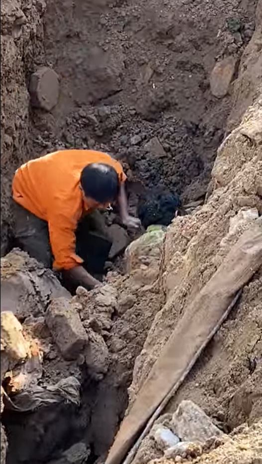  
Công nhân phát hiện 1 người ở dưới lòng đất. (Ảnh: Cắt từ clip)