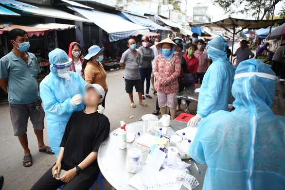  
Cư dân sống gần khu vực bệnh nhân 2910 ở Bình Tân được lấy mẫu xét nghiệm Covid-19. (Ảnh: Tuổi Trẻ)