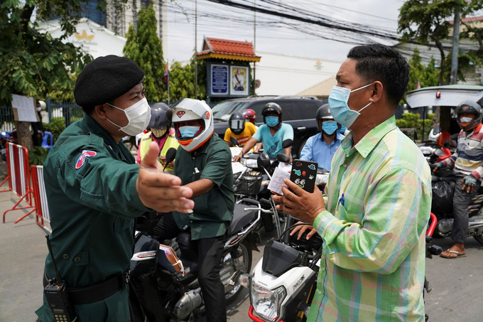  
Những người muốn ra vào khu vực phong tỏa phải đeo khẩu trang và phải có giấy thông hành. (Ảnh: Khmer Times)
