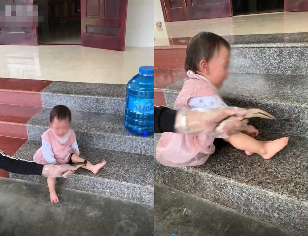  
Người con khóc khi bị mẹ dùng cá lóc đánh vào chân. (Ảnh: Chụp màn hình)