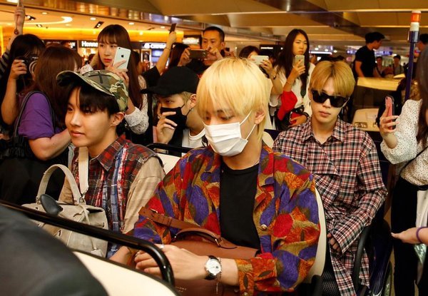  
Vẻ mặt chịu đựng của BTS khi bị fan cuồng bám riết ở sân bay. (Ảnh: Twitter)