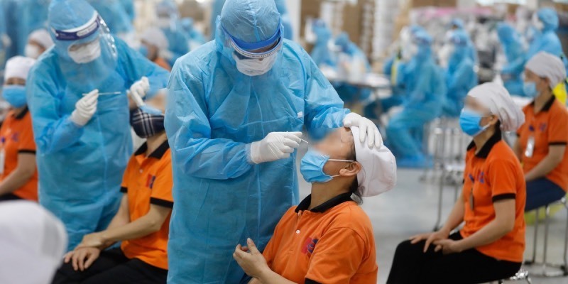  
Nhân viên y tế lấy mẫu xét nghiệm của công nhân. (Ảnh: Bộ Y tế)