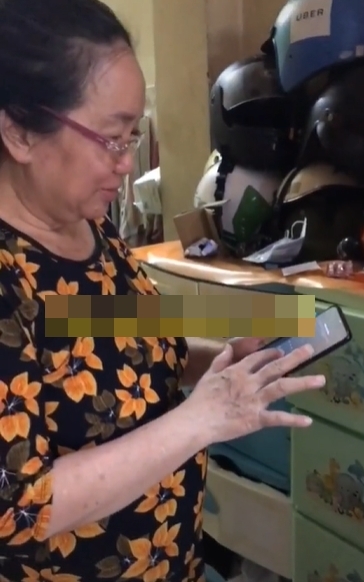  
Người mẹ xuất hiện trong đoạn clip đang sử dụng điện thoại. (Ảnh: Cắt từ video)