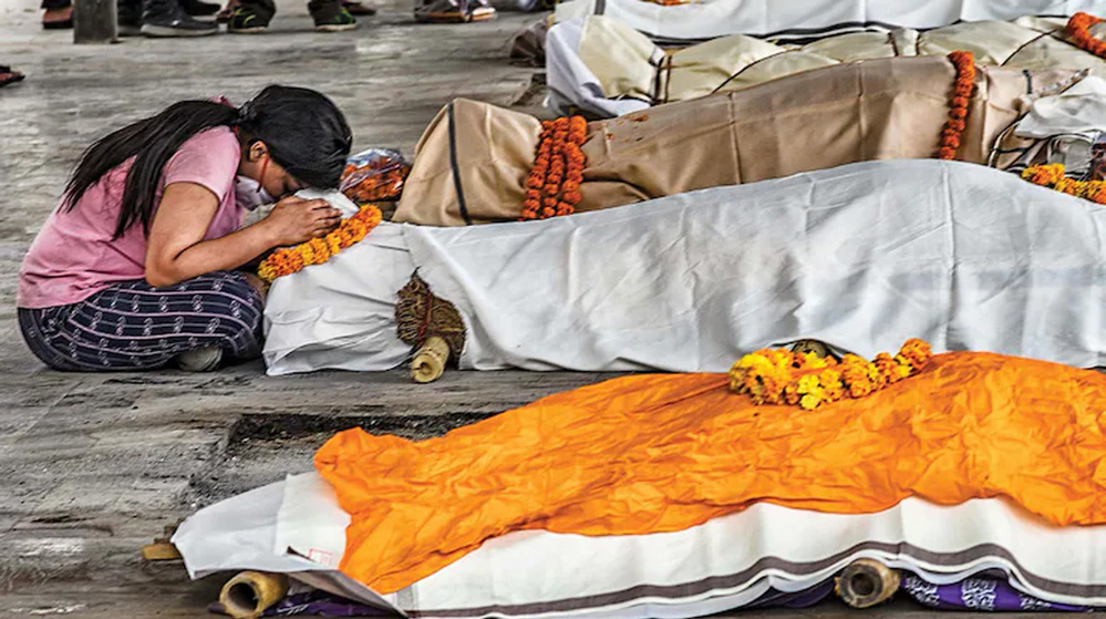  
Người thân cầu nguyện trước thi hài bệnh nhân đã khuất. (Ảnh: India Today)