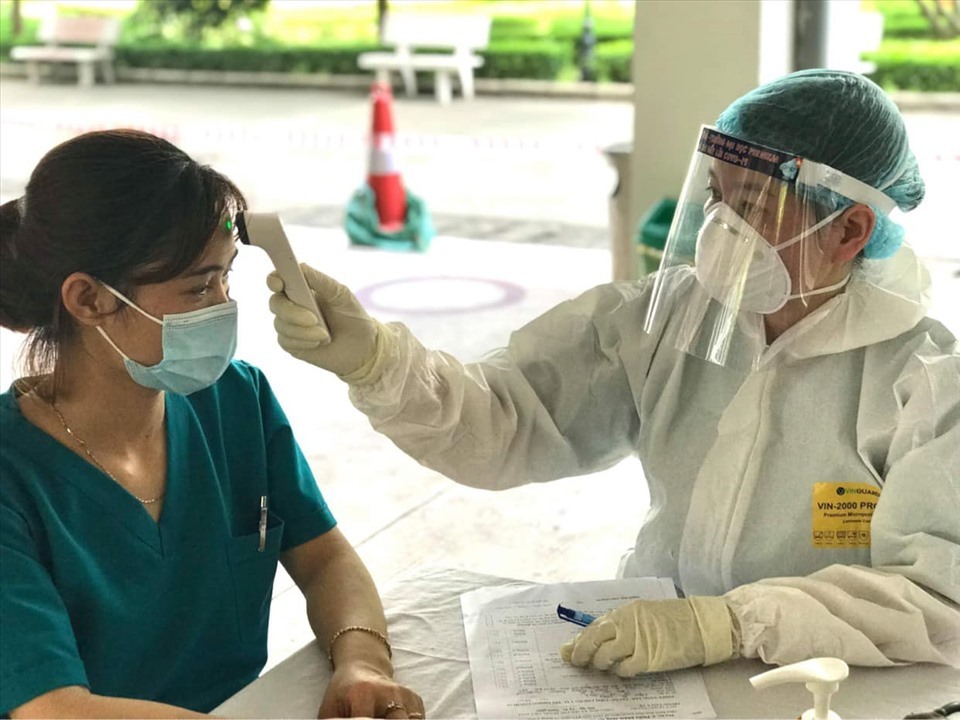 Nhân viên y tế đo thân nhiệt. (Ảnh: Lao Động)