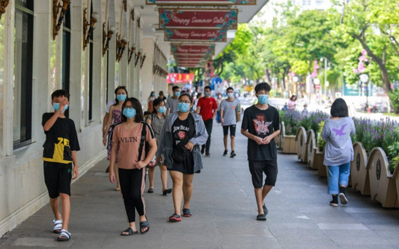  
Mọi người đeo khẩu trang đi dạo tại Hà Nội. (Ảnh: Báo Chính Phủ)