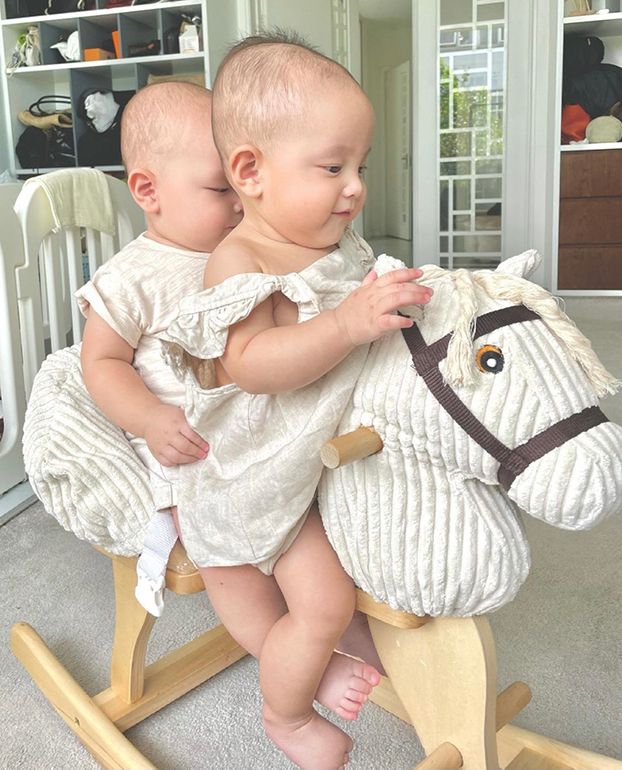  
Hai chị em lộ vẻ hớn hở khi được mẹ cho cưỡi ngựa gỗ. (Ảnh: IGNV)