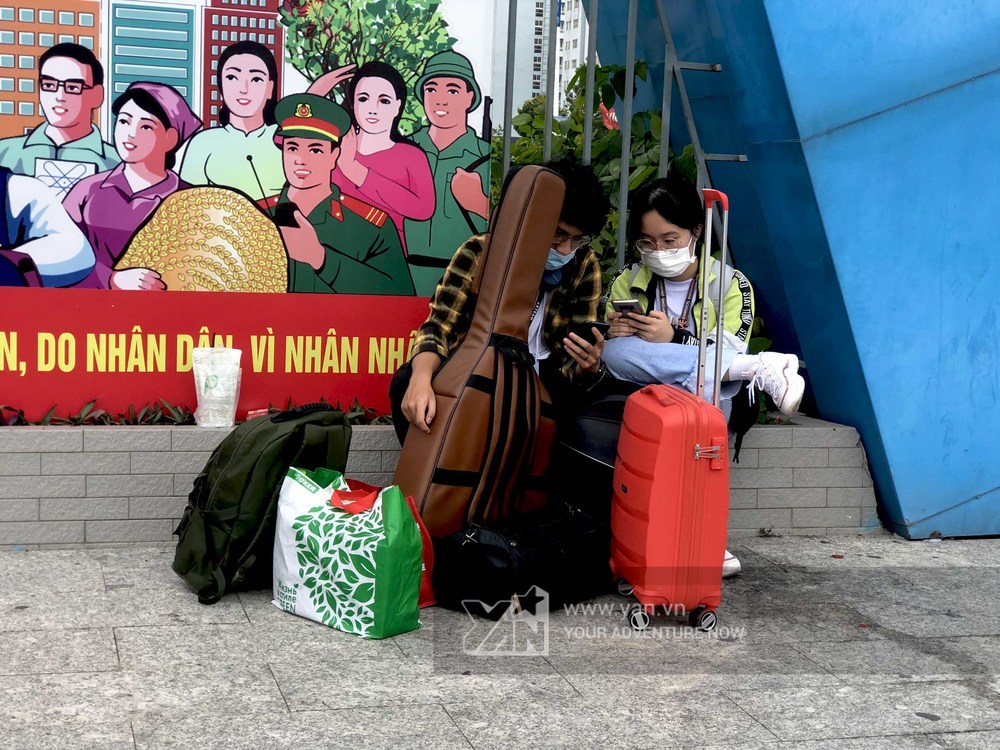  
Hai bạn sinh viên đã dọn xong hành lý, ngồi chờ xe trước cổng KTX khu B - ĐHQG TP. Hồ Chí Minh.