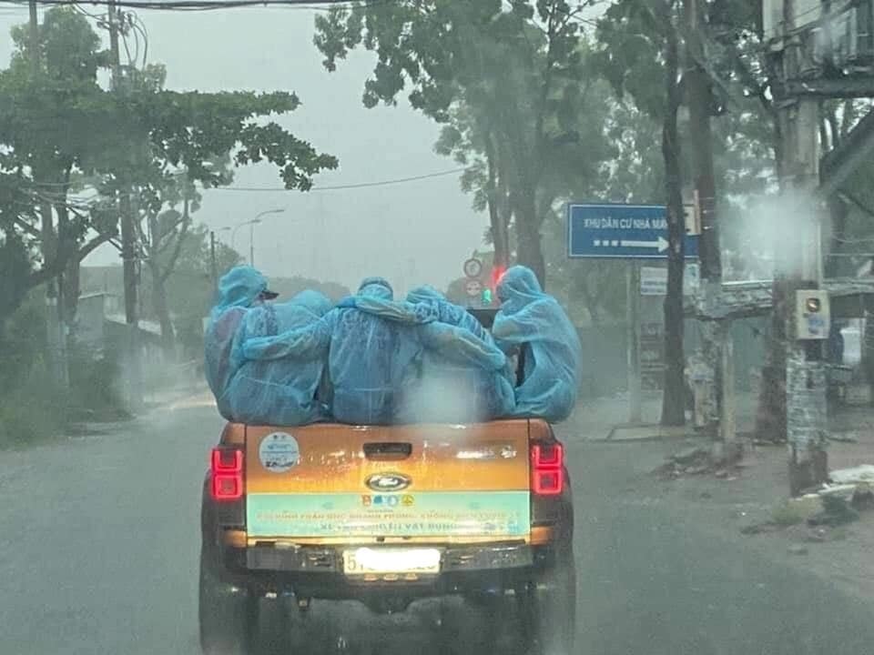  
"Các chiến sĩ áo xanh" ôm nhau giữa trời mưa lớn. (Ảnh: Sài Gòn)