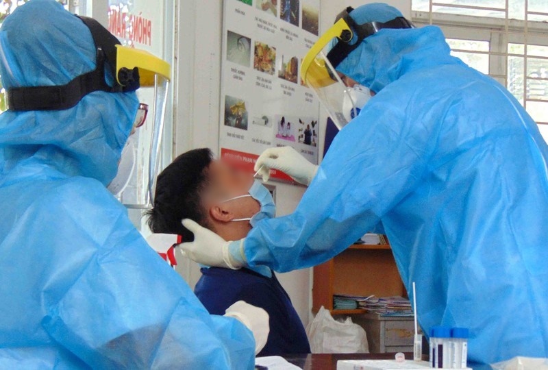  Nhân viên y tế lấy mẫu xét nghiệm mũi, họng. (Ảnh: Pháp Luật TP.HCM)