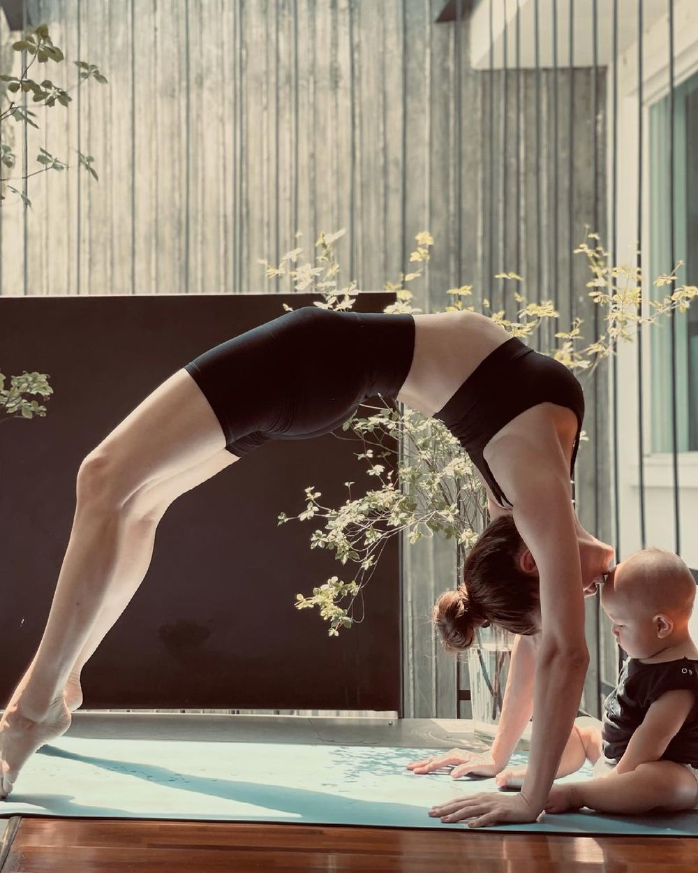  Hồ Ngọc Hà tạo dáng yoga siêu khó, còn tranh thủ hôn nhóc tì Leon. (Ảnh: Instagram)