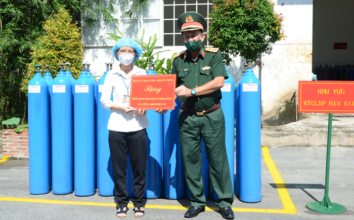  
Thượng tướng trao tặng bình 1.000 bình oxy cho đại diện Bệnh viện Đa khoa Tân Bình. (Ảnh: Bộ Quốc Phòng)
