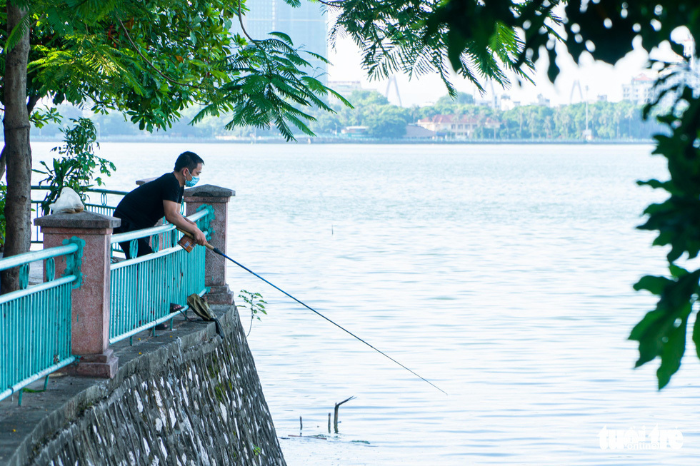 Người đàn ông câu cá tại đường Nguyễn Đình Thi (Q.Tây Hồ) trong thời điểm giãn cách xã hội. (Ảnh: Tuổi trẻ Online)